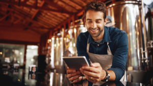 man smiling at an iPad
